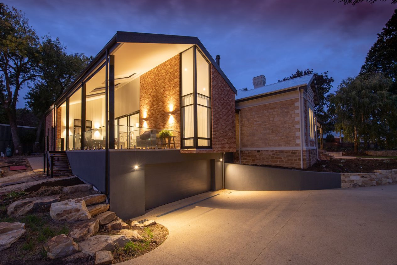 Stylish modern brick residential home illuminated at twilight, showcasing contemporary architecture.