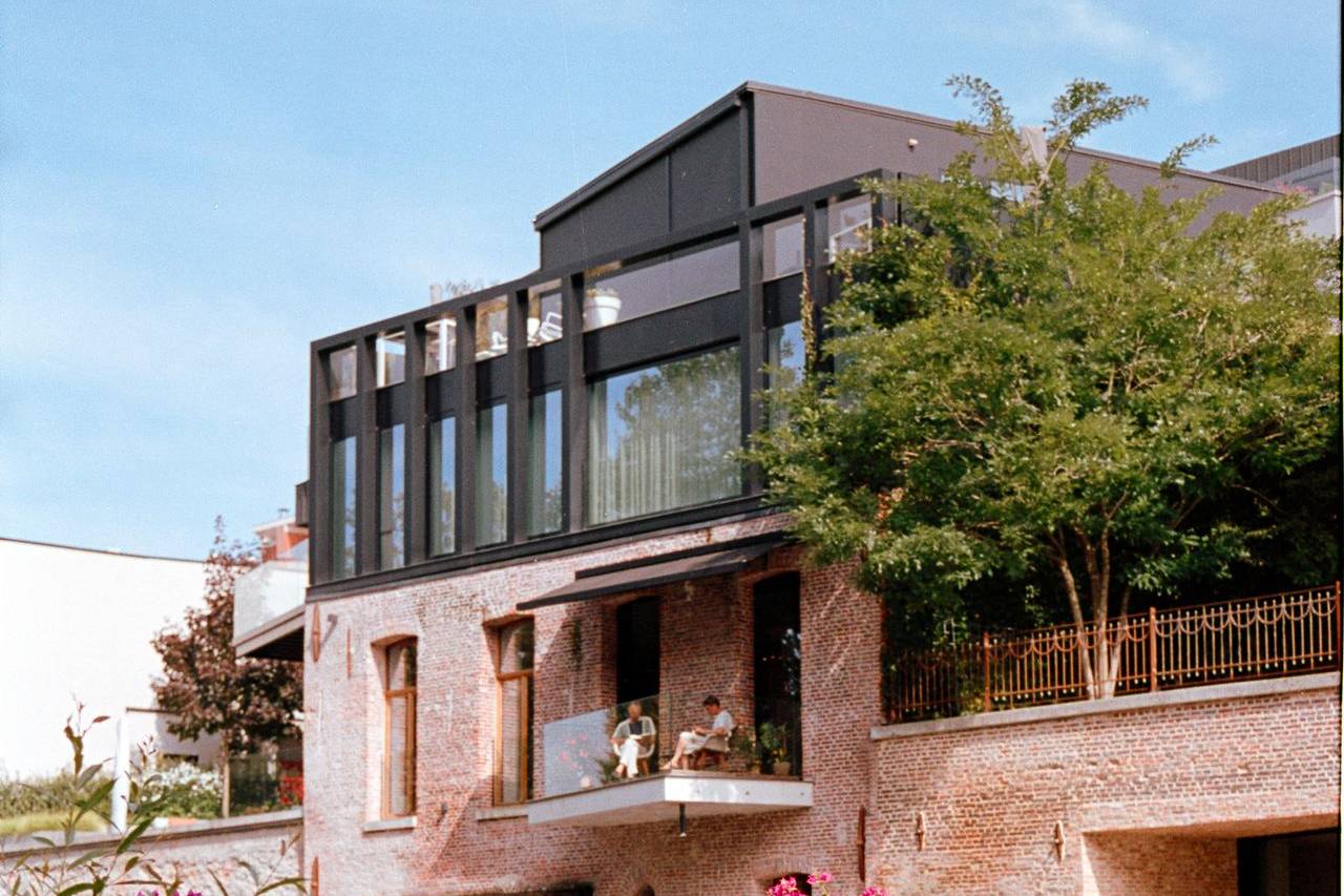 A picturesque canal house with flourishing greenery, and a sunny summer day.